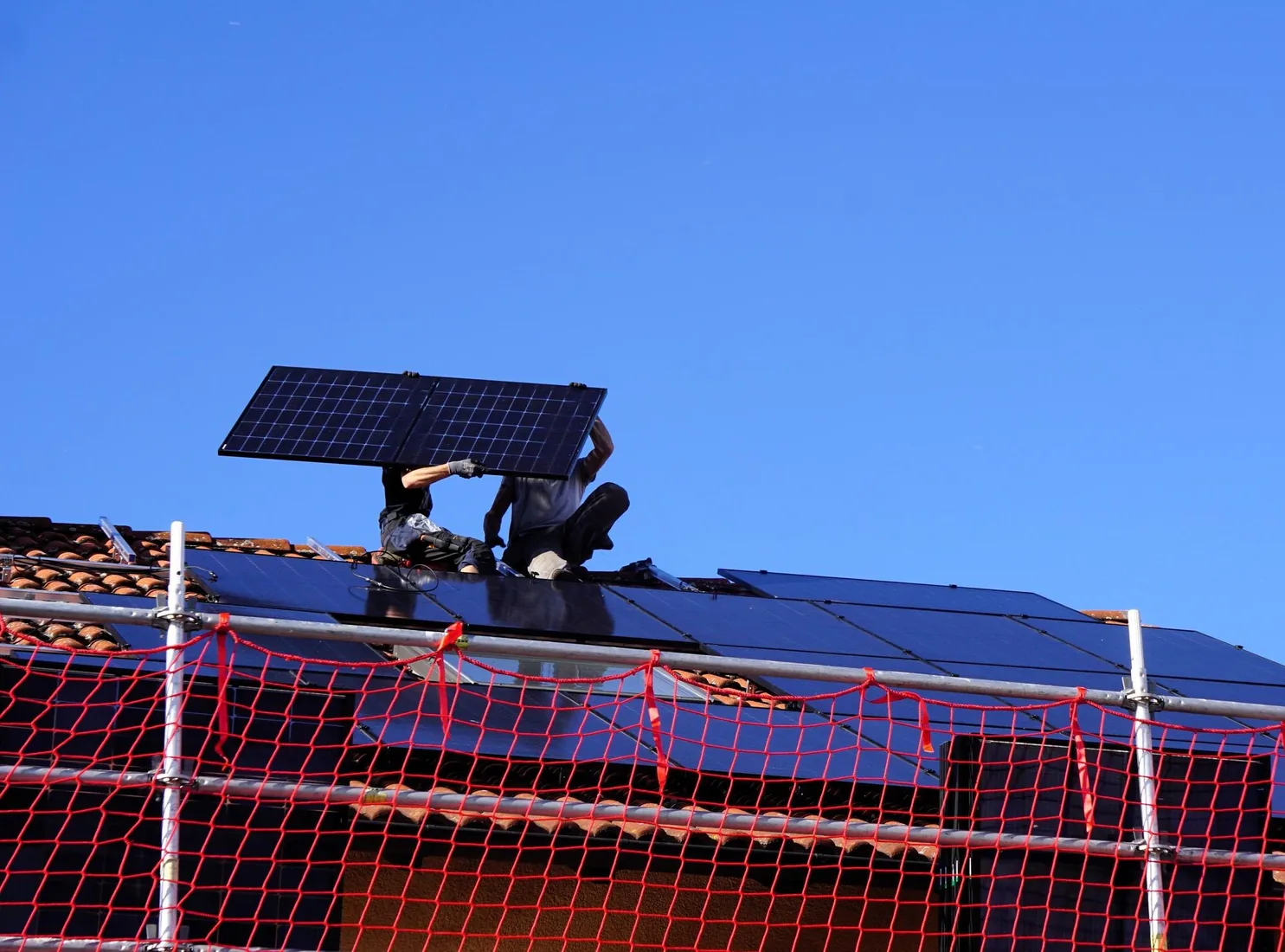 Installateur posant des panneaux solaires photovoltaïques, achat, installation et raccordement sur toiture